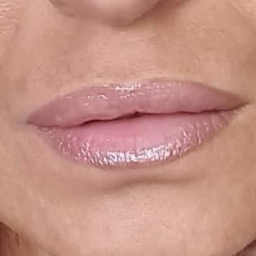 Nahaufnahme von Lippen mit feinem Glanz, leicht rosa gefärbt.
