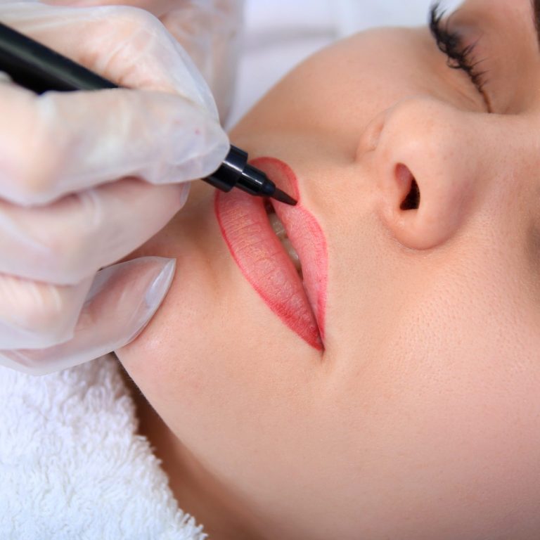 Eine Person erhält eine Lippenkonturierung mit einem Permanent-Make-up-Stift.